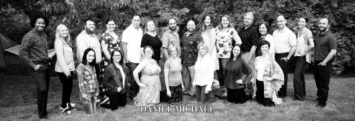 a group of men and women standing and kneeling together for a picture